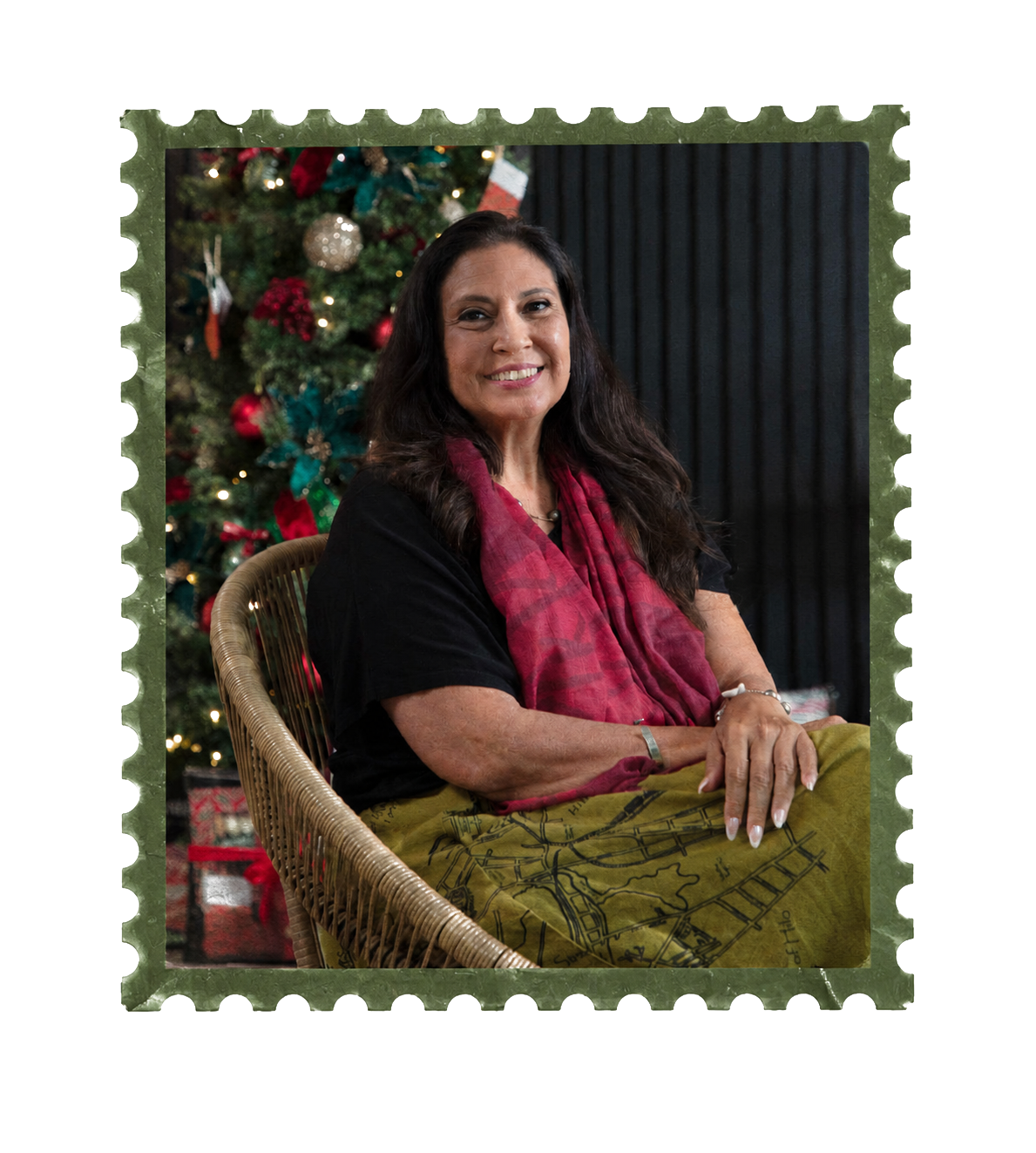 Jalene Kanani seated in a wicker chair beside a decorated tree